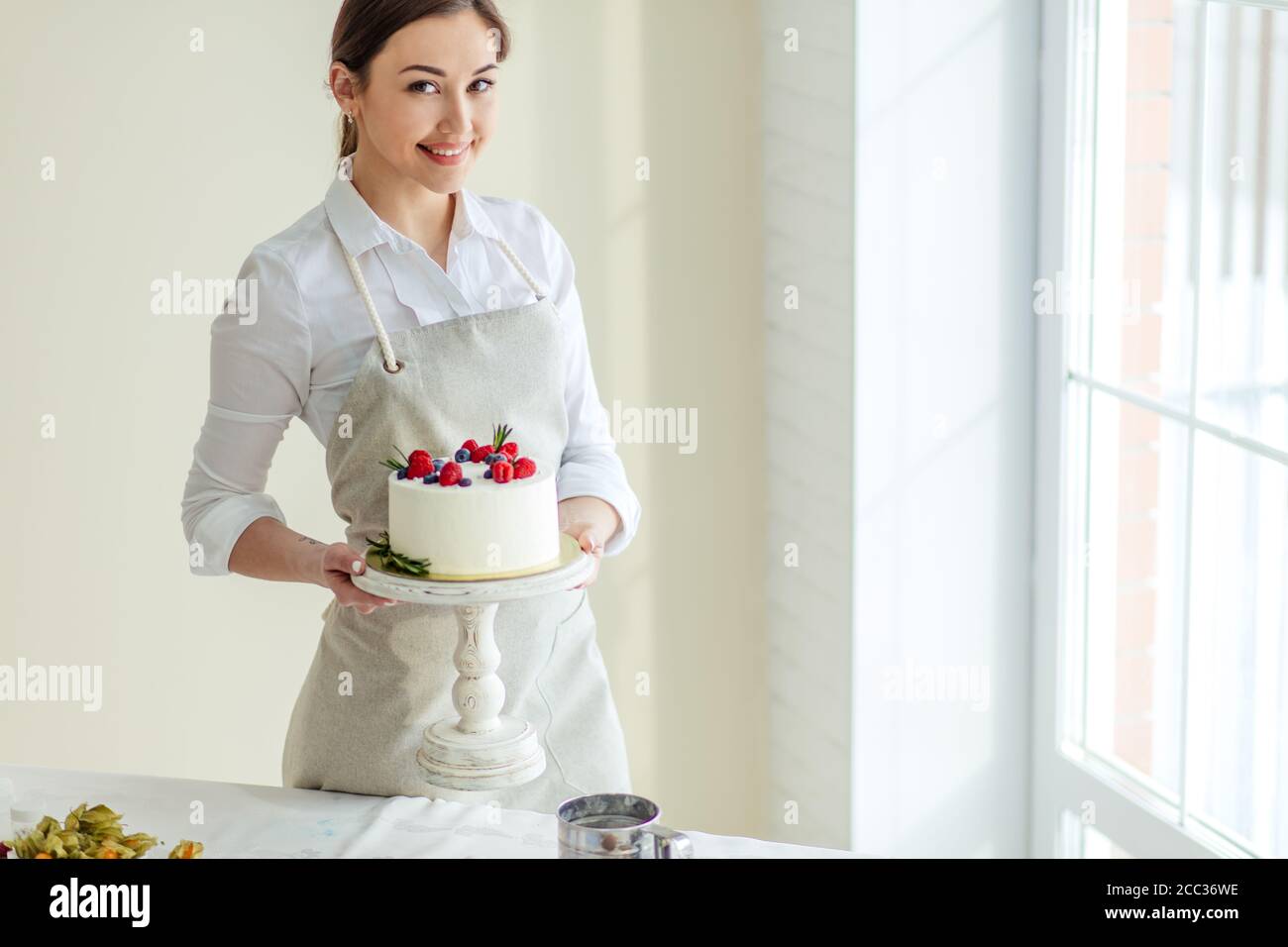 jeune mère souriante tenant un gâteau d'anniversaire dans le kithcen avec intérieur moderne. gros plan photo. copier espace.hobby Banque D'Images