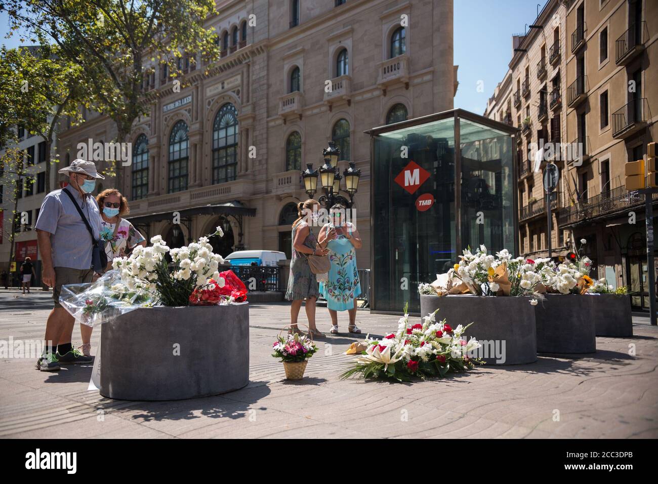 Les personnes portant des masques de visage observent les hommages aux victimes de l'attaque de Barcelone.trois ans après l'attaque de Barcelone, un hommage aux victimes est rendu à Las Ramblas. Banque D'Images