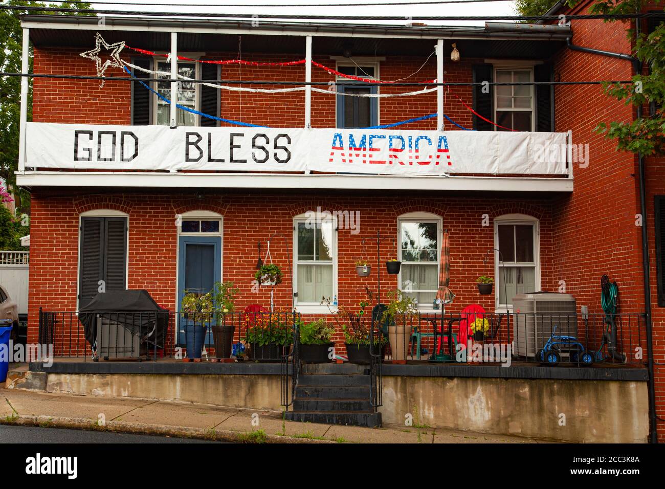 Frederick, MD, USA 08/14/2020: Une vieille maison de deux étages avec des jouets et des plantes en pot au premier étage et une grande bannière en tissu qui dit ' Banque D'Images