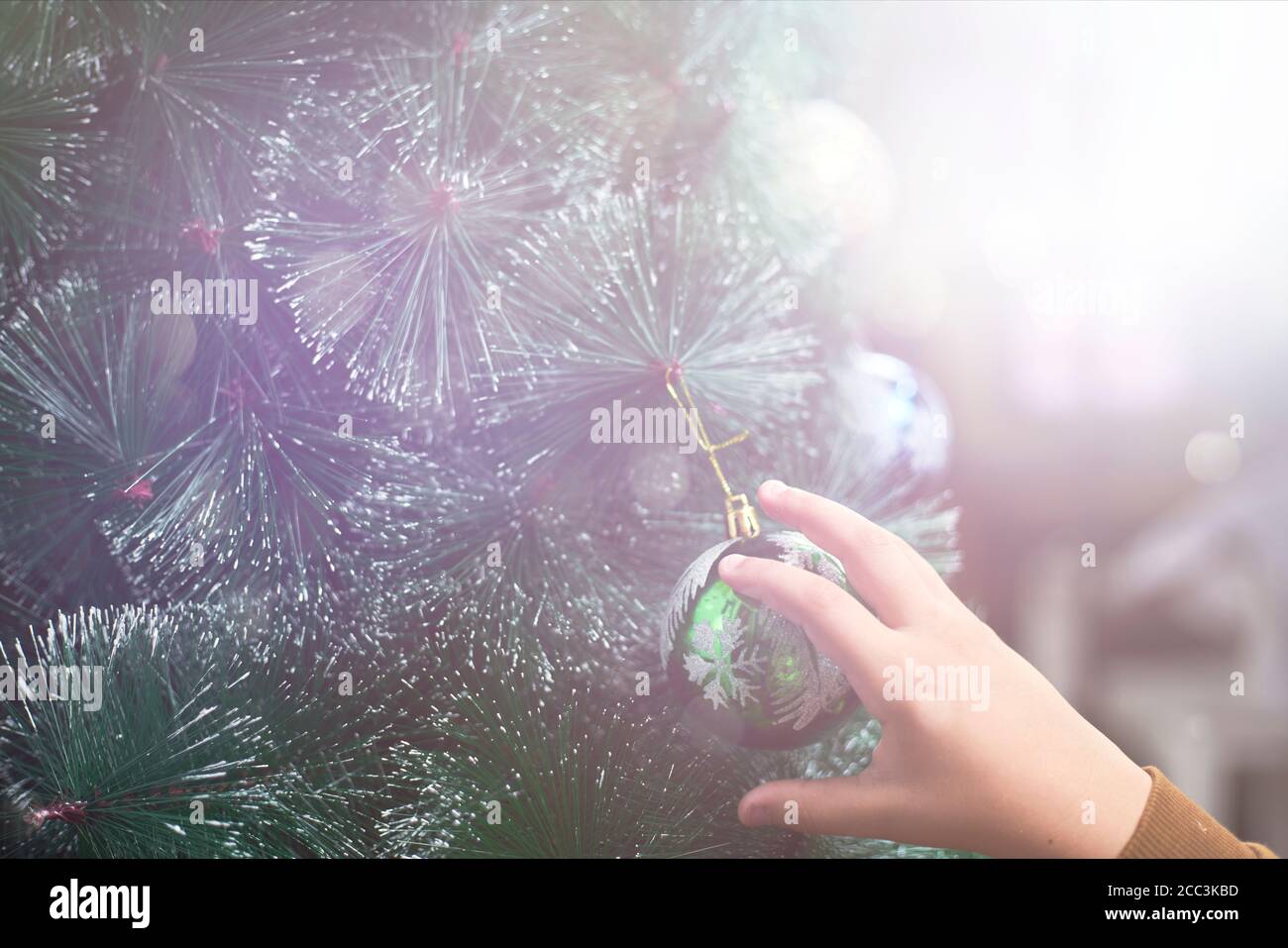 Petit enfant décorant arbre de Noël. Garçon tenant Noël orné. Arrière-grouind de Noël Banque D'Images