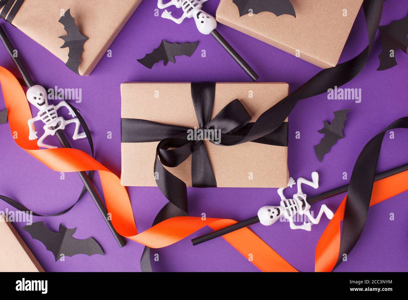 Boîtes-cadeaux d'Halloween avec ruban et décoration en papier sur fond violet traditionnel. Fêtes, anniversaire, Halloween fête concept, saison Banque D'Images