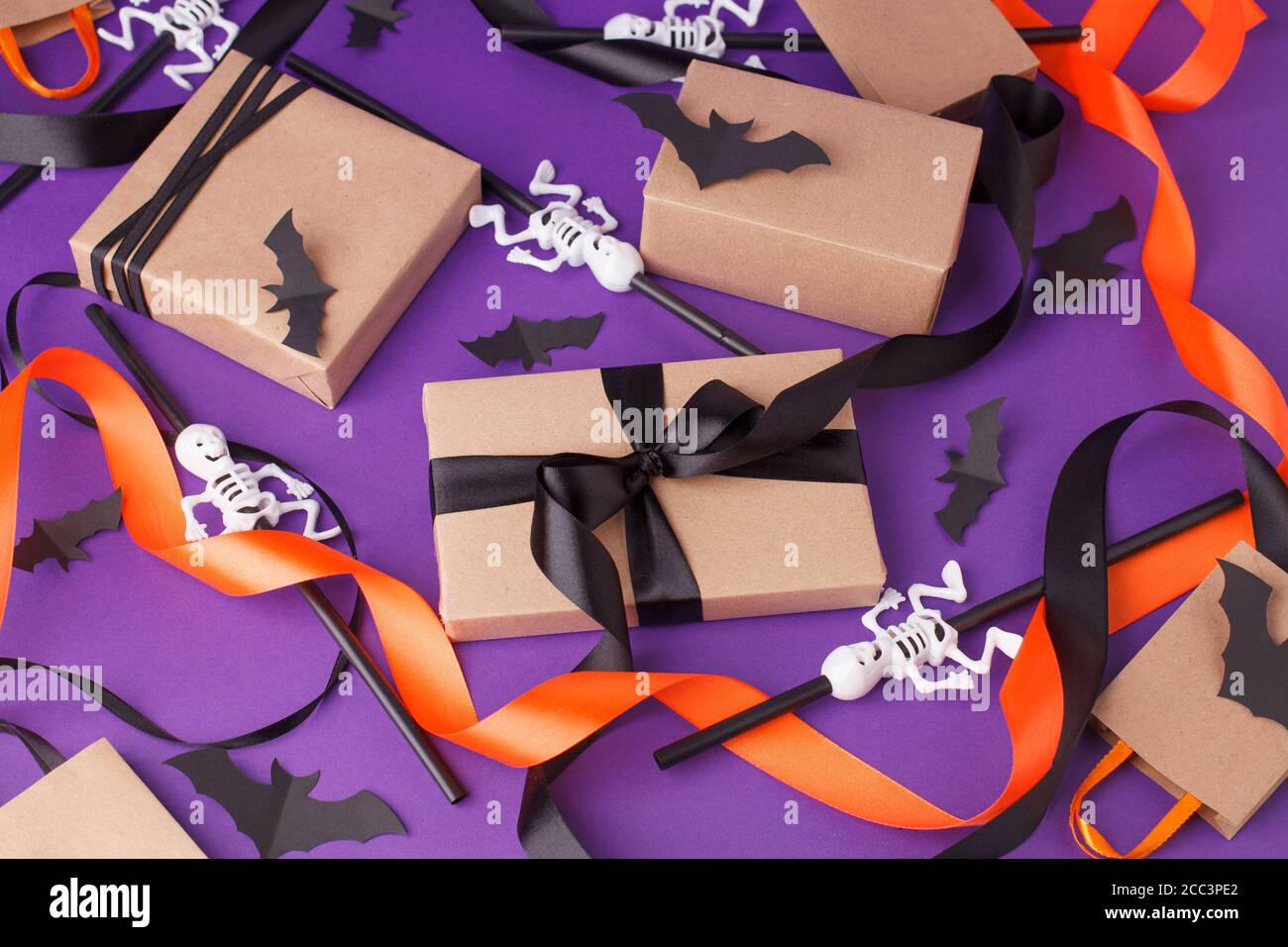 Boîtes-cadeaux d'Halloween avec ruban et décoration en papier sur fond violet traditionnel. Fêtes, anniversaire, Halloween fête concept, saison Banque D'Images