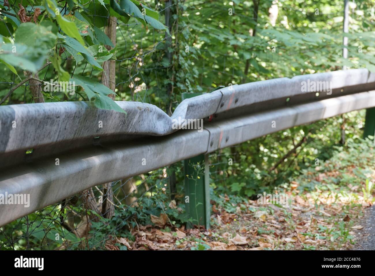 Barrières ou rails de protection métalliques endommagés en raison d'une collision avec un véhicule. Les barrières bordent la route secondaire dans les collines au-dessus de la ville de Fribourg. Banque D'Images Barrières ou rails de protection métalliques endommagés en raison d'une collision avec un véhicule. Les barrières bordent la route secondaire dans les collines au-dessus de la ville de Fribourg. Banque D'Images