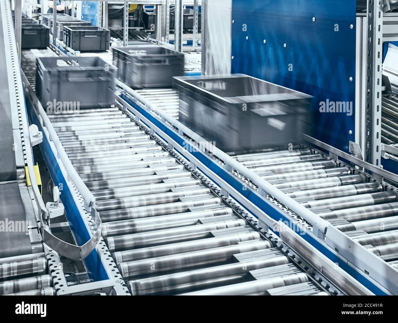 Système de convoyeur à rouleaux moderne avec boîtes en mouvement, faible profondeur de champ. Banque D'Images