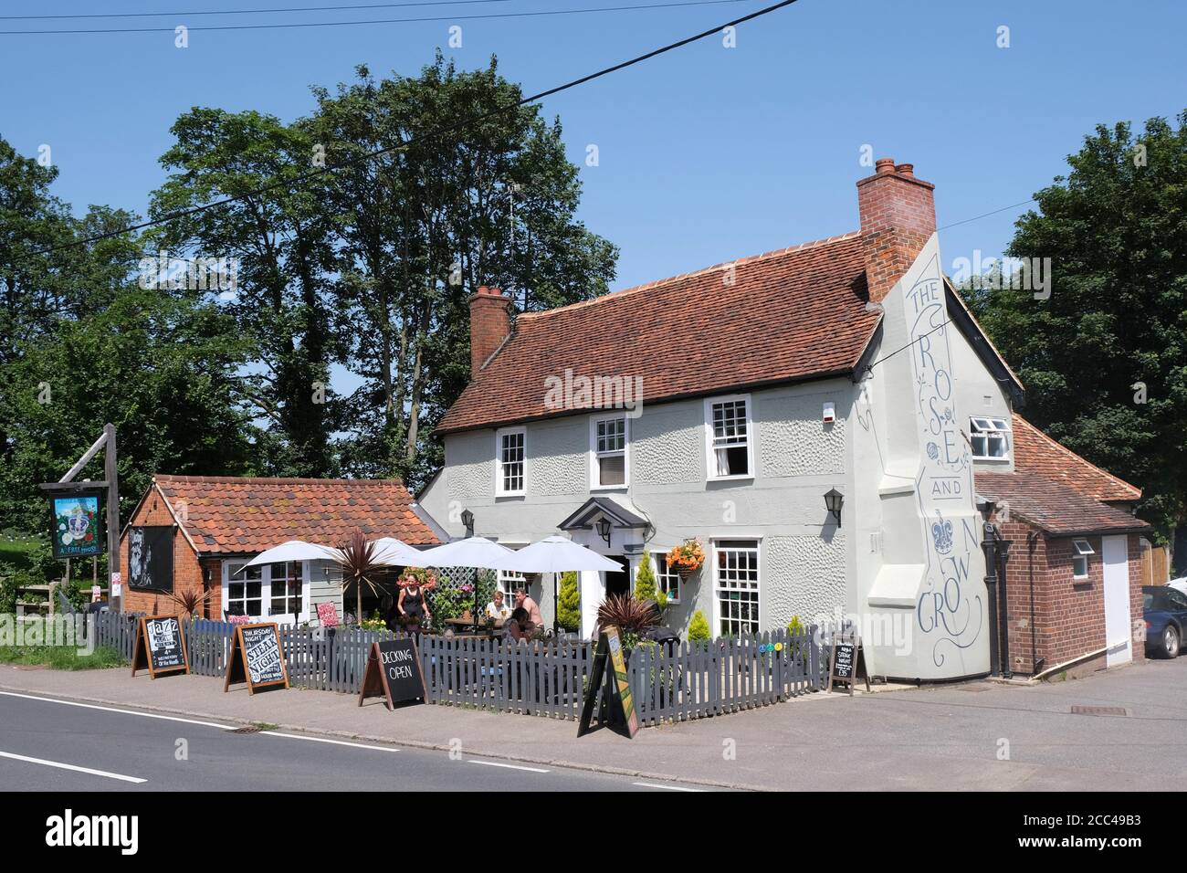 Personnes assises à l'extérieur du pub Rose and Crown à Great Waltham, Essex, Angleterre. Banque D'Images