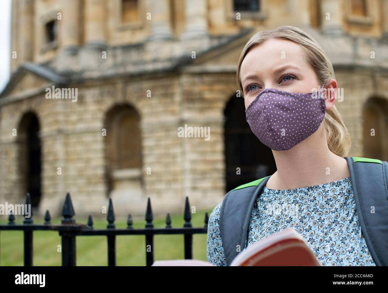 Femme touriste sur les vacances portant un masque facial pendant la pandémie Covid-19 Lire le guide touristique réserver à Oxford UK Banque D'Images Femme touriste sur les vacances portant un masque facial pendant la pandémie Covid-19 Lire le guide touristique réserver à Oxford UK Banque D'Images
