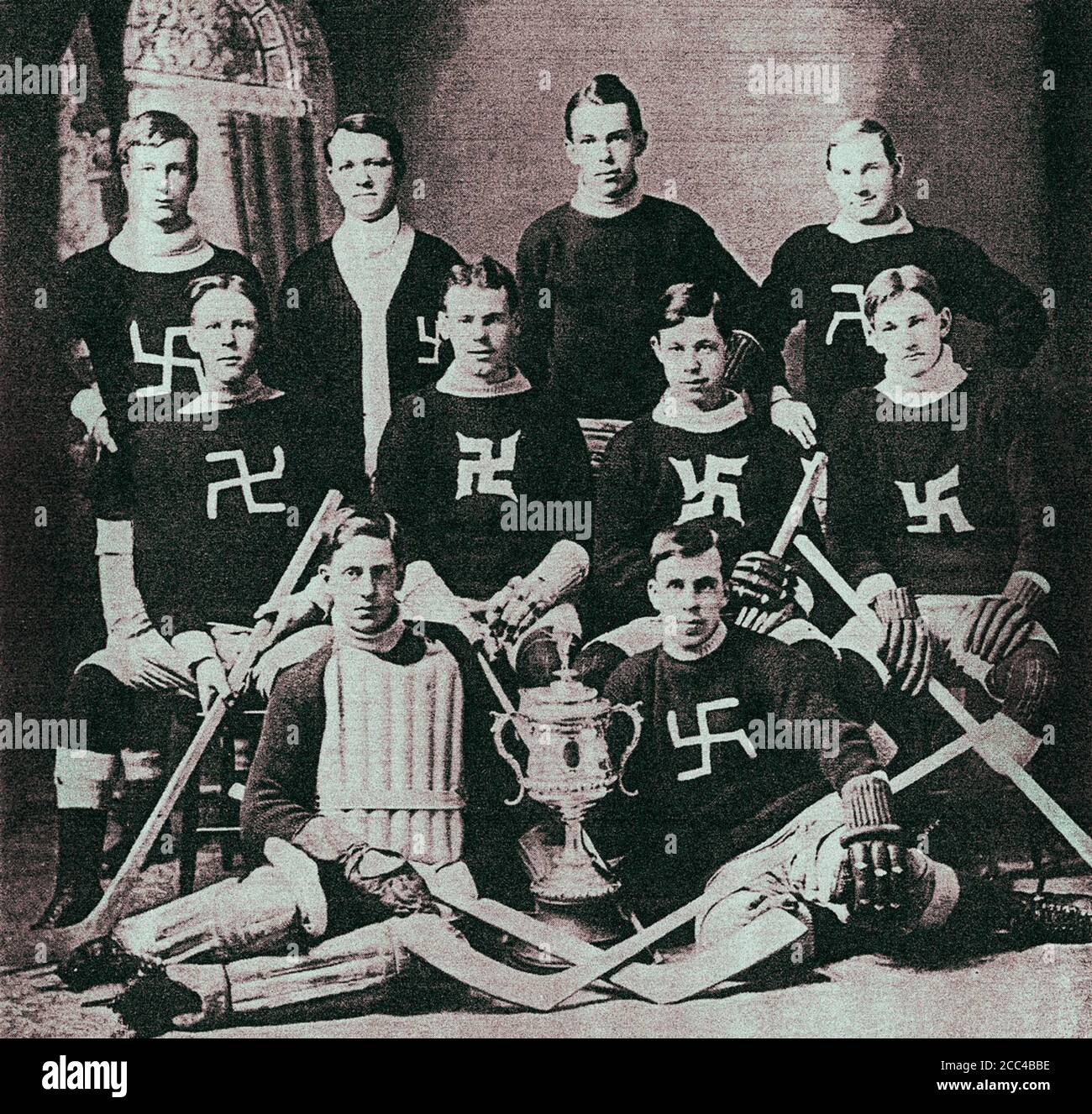 Photo rétro d'une équipe canadienne de hockey avec un signe de la croix gammée sur ses chandails. 1910s Banque D'Images
