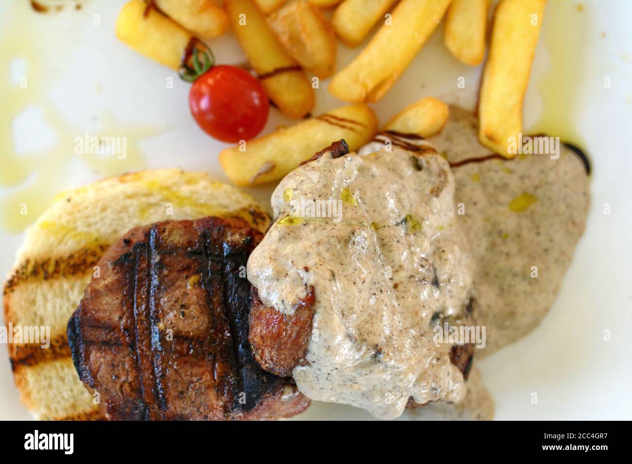 Steak de bœuf rôti moyen avec une sauce aux truffes. Steak grillé avec pommes de terre tard. Banque D'Images