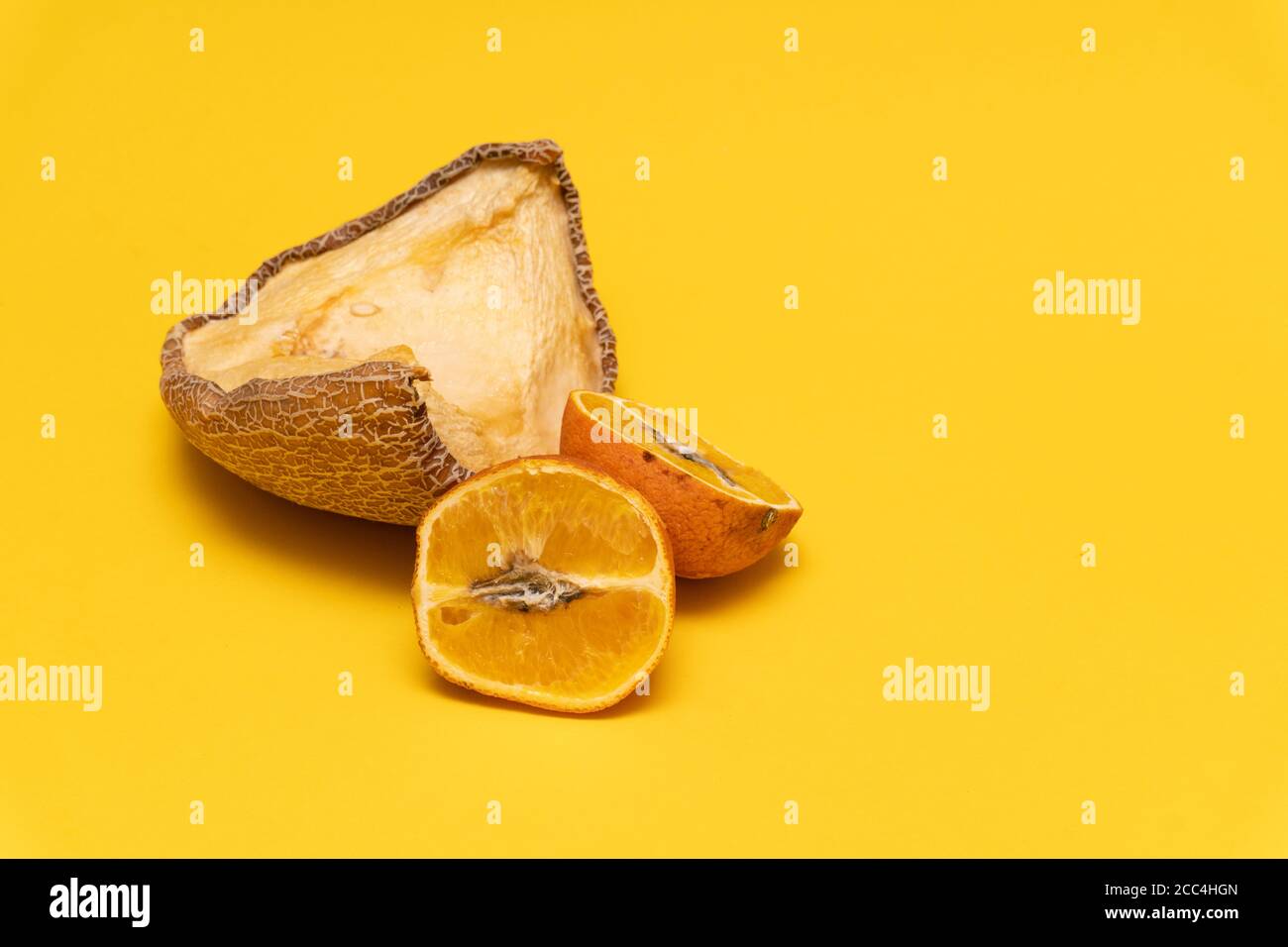 Composition créative avec melon jaune séché et mandarines orange mouleuses, fond jaune, non comestible Banque D'Images