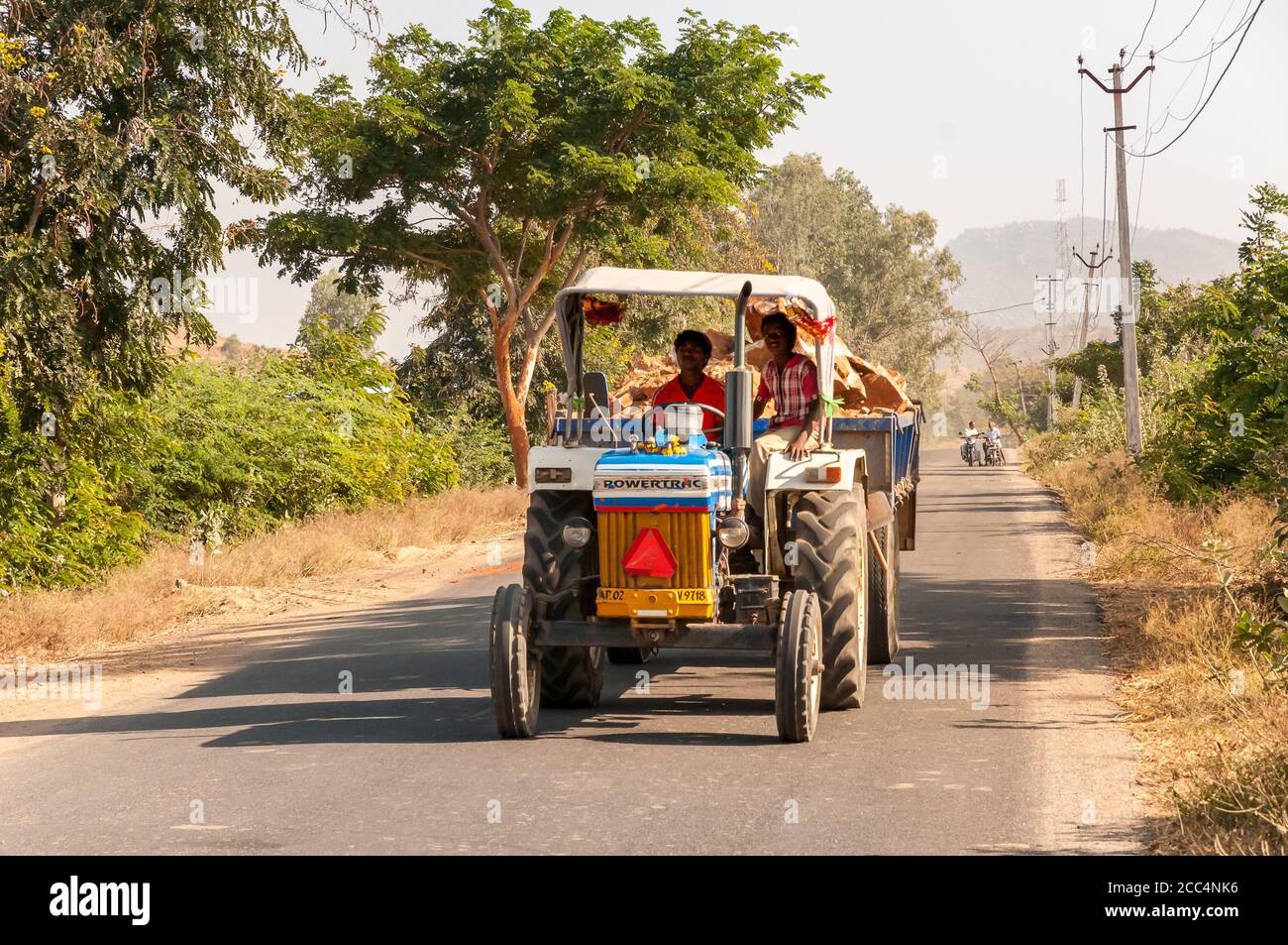 Puttaparthi, Andhra Pradesh, Inde - 12 janvier 2013 : les travailleurs indiens sur le tracteur transportent le bois, sur la route du village de Puttaparthi, Inde Banque D'Images