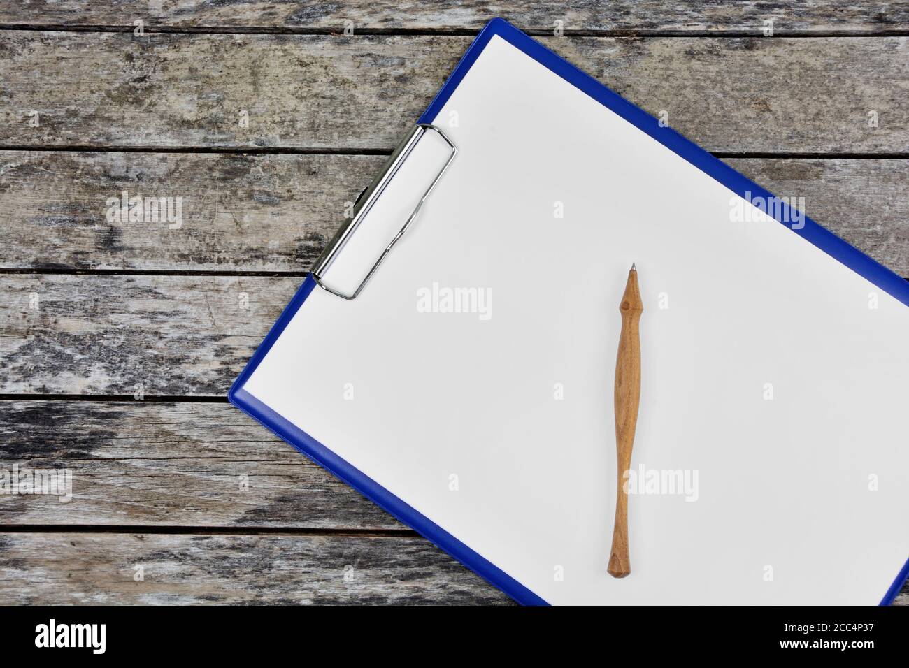 Gros plan du presse-papiers avec du papier blanc vierge et un stylo sur une ancienne table en bois Banque D'Images