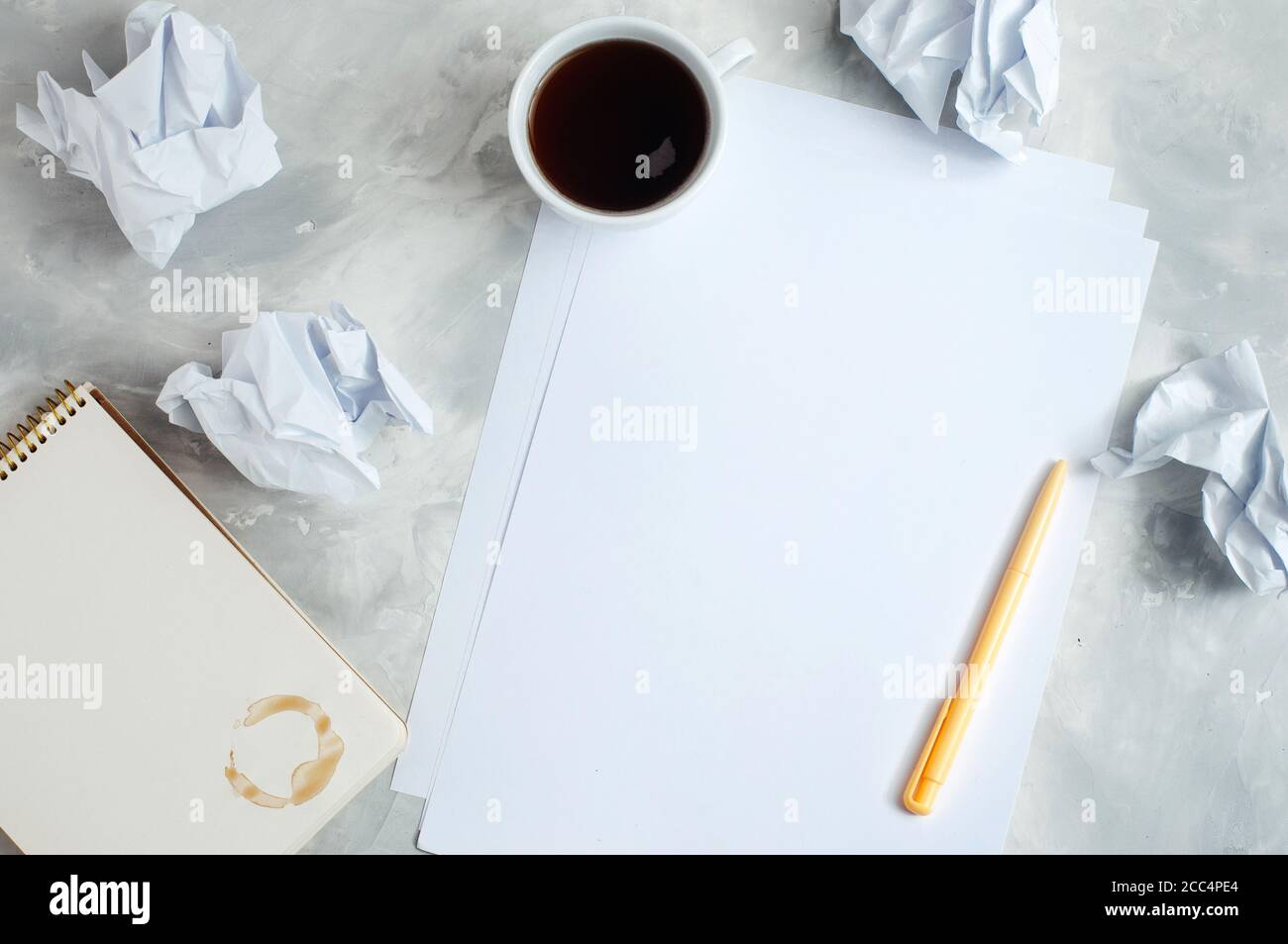 Remue-méninges avec du papier froissé, un carnet et une tasse de café Banque D'Images