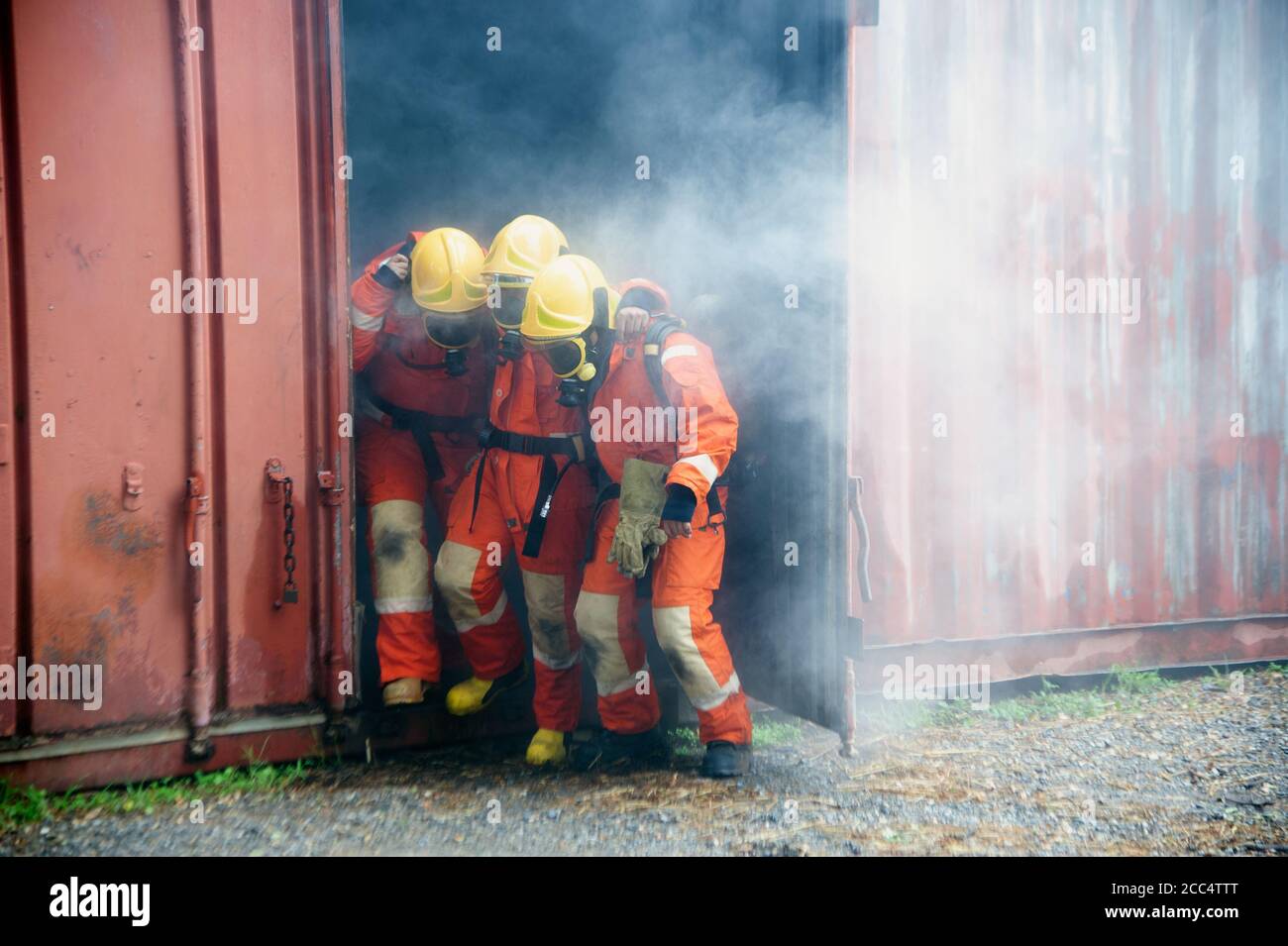 Les pompiers aident les travailleurs en sortant du bâtiment en feu . Banque D'Images