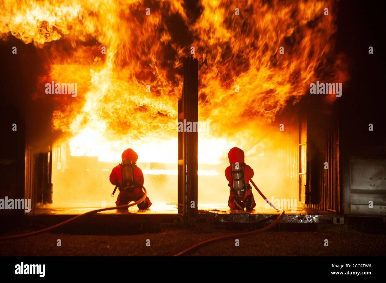 Les pompiers pulvérisent de l'eau pour faire un incendie brutal à l'intérieur du bâtiment. Banque D'Images