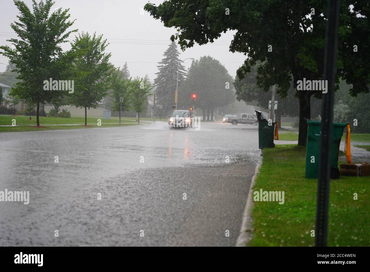 Les citoyens de fond du Lac traversent les rues inondées dans leurs véhicules de l'énorme déversage de pluie durant l'après-midi de juillet 2020. Banque D'Images