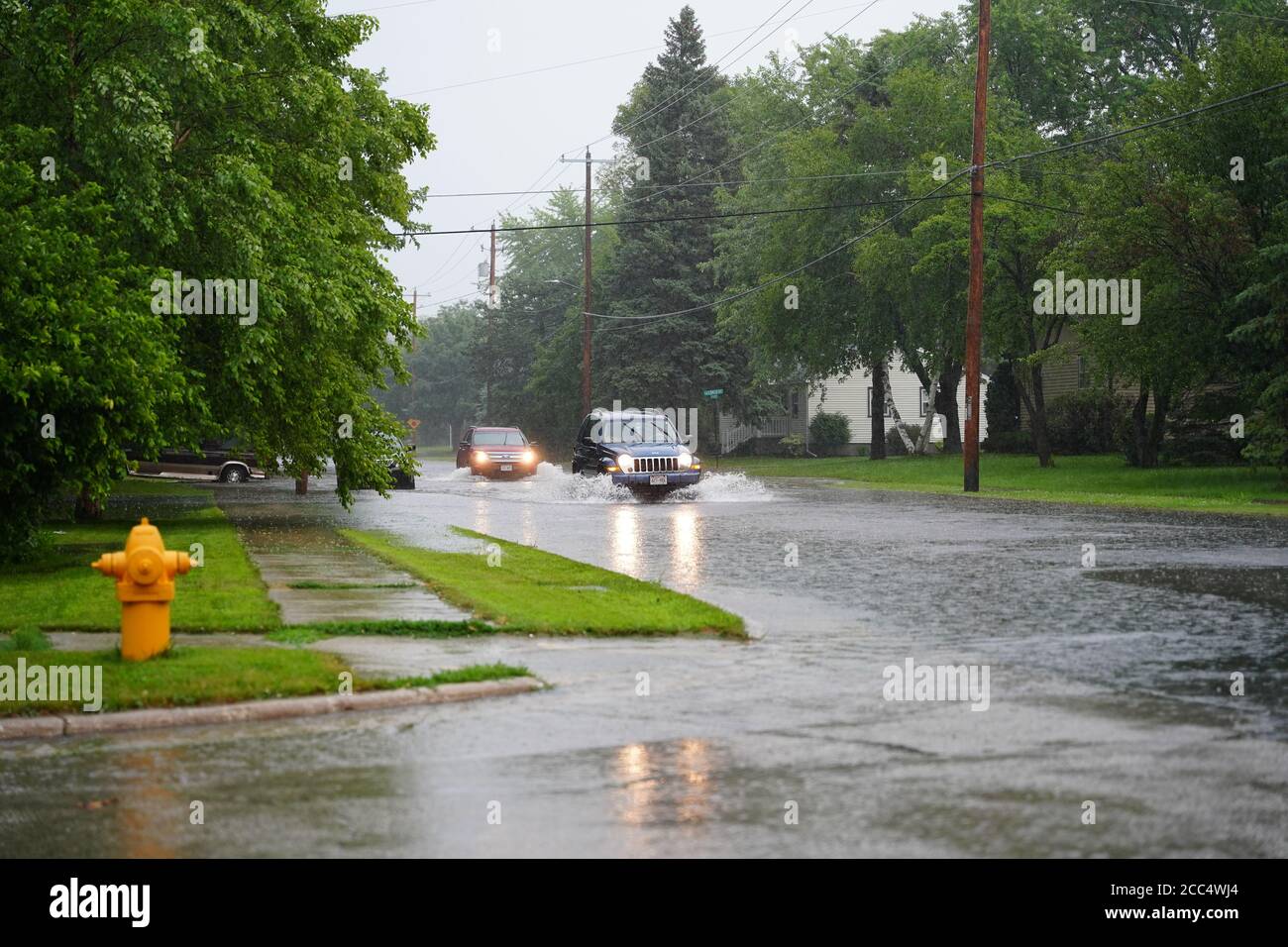 Les citoyens de fond du Lac traversent les rues inondées dans leurs véhicules de l'énorme déversage de pluie durant l'après-midi de juillet 2020. Banque D'Images