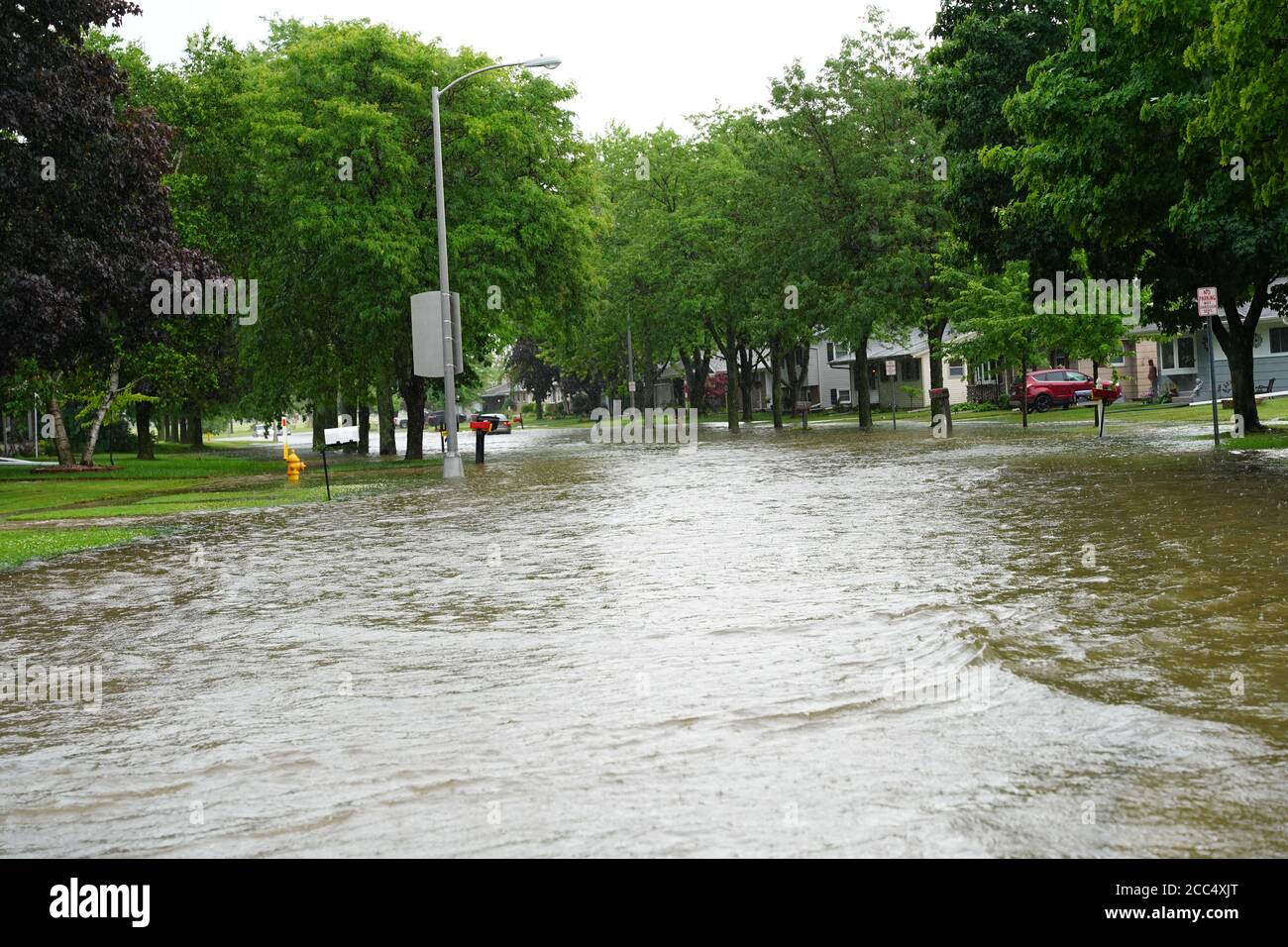 Les citoyens de fond du Lac traversent les rues inondées dans leurs véhicules de l'énorme déversage de pluie durant l'après-midi de juillet 2020. Banque D'Images