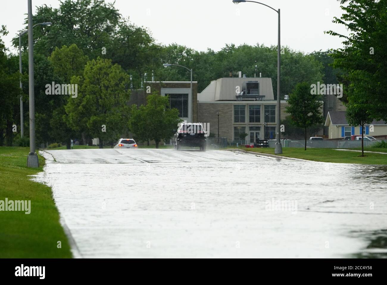 Les citoyens de fond du Lac traversent les rues inondées dans leurs véhicules de l'énorme déversage de pluie durant l'après-midi de juillet 2020. Banque D'Images