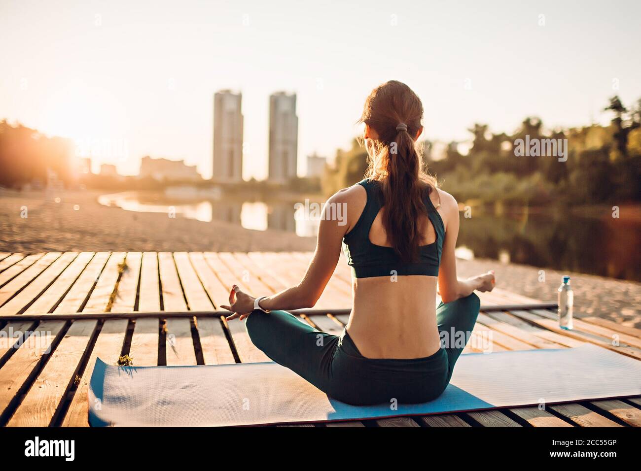 la sportswoman médite au lever du soleil Banque D'Images