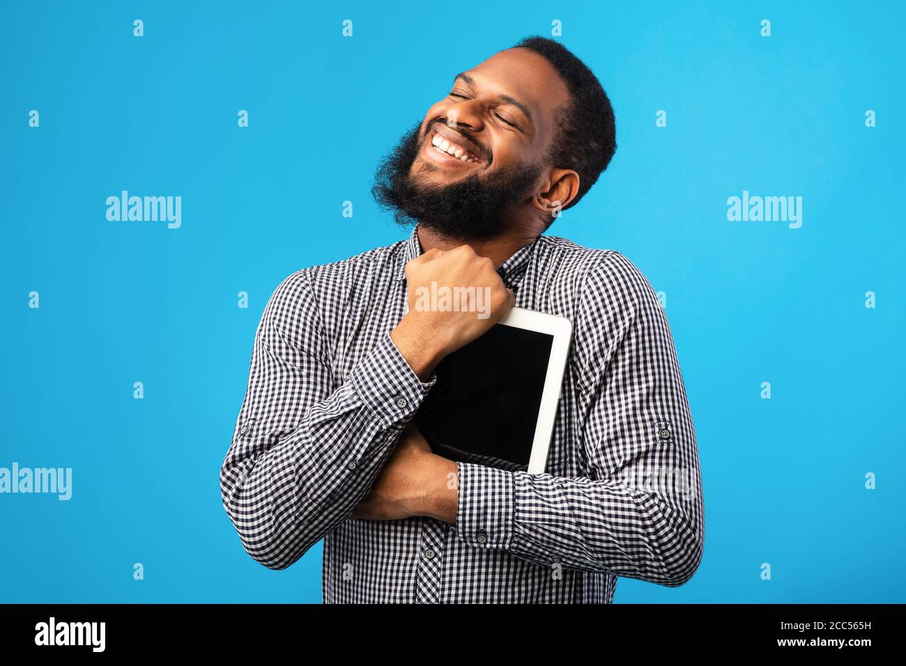 Homme afro-américain souriant tenant une tablette numérique Banque D'Images