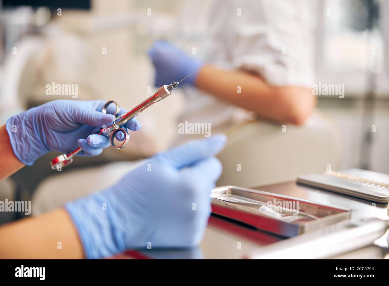 Se concentrer sur les mains de l'homme tenant l'instrument pour la manipulation avec les dents Banque D'Images