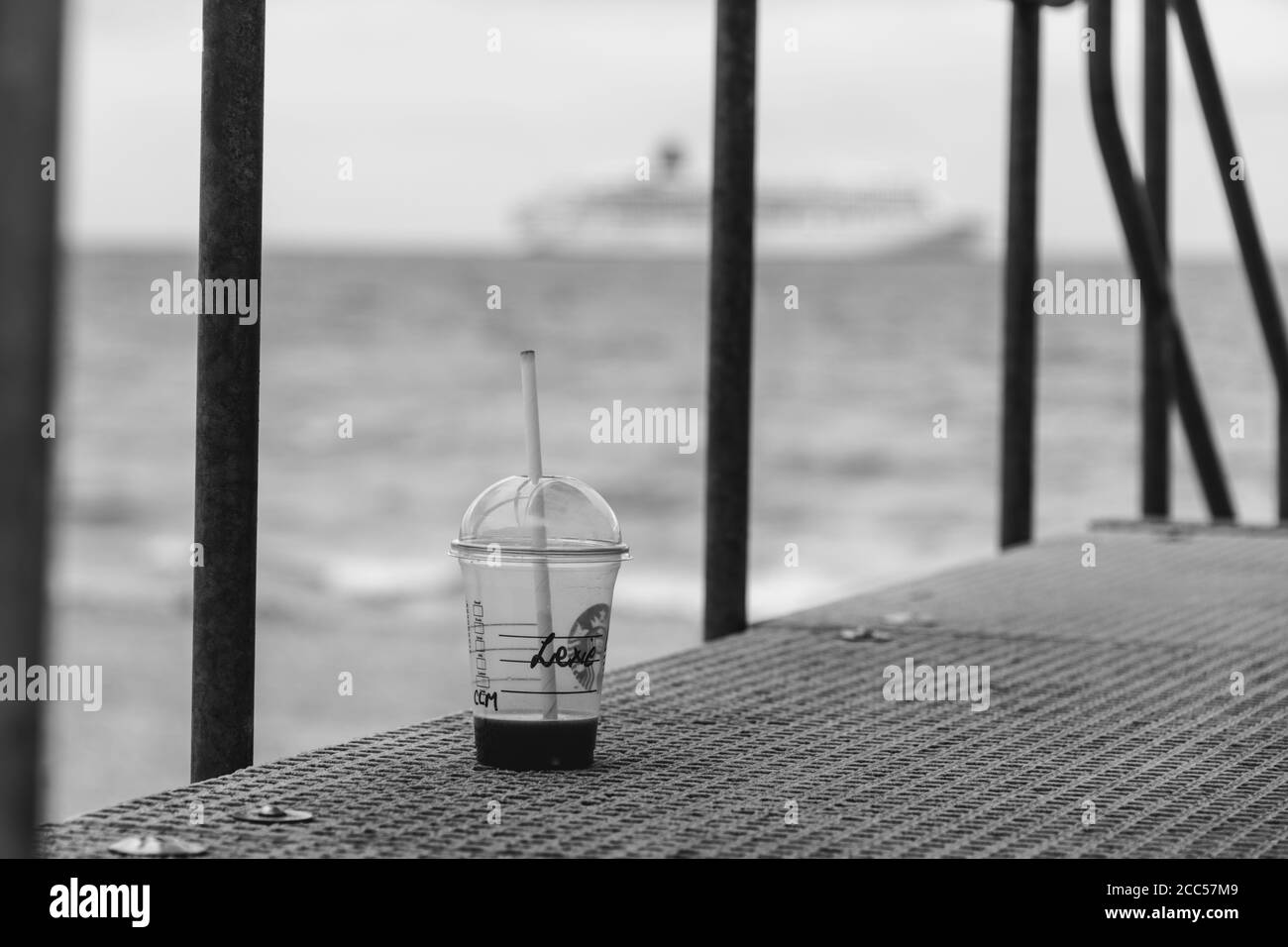 Pollution plastique : tasse Starbucks laissée par les touristes à la plage. Bateau de croisière P&O en arrière-plan. Bournemouth, Royaume-Uni. Banque D'Images