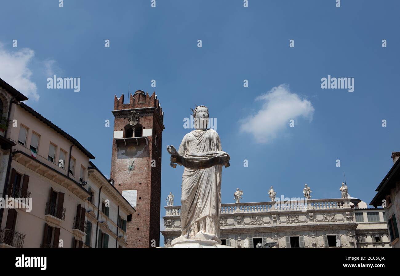 La fontaine de la Madonna de Vérone sur la Piazza Erbe, avec la Torre del Gardello derrière. La statue est un symbole célèbre de l'ancienne ville. Banque D'Images