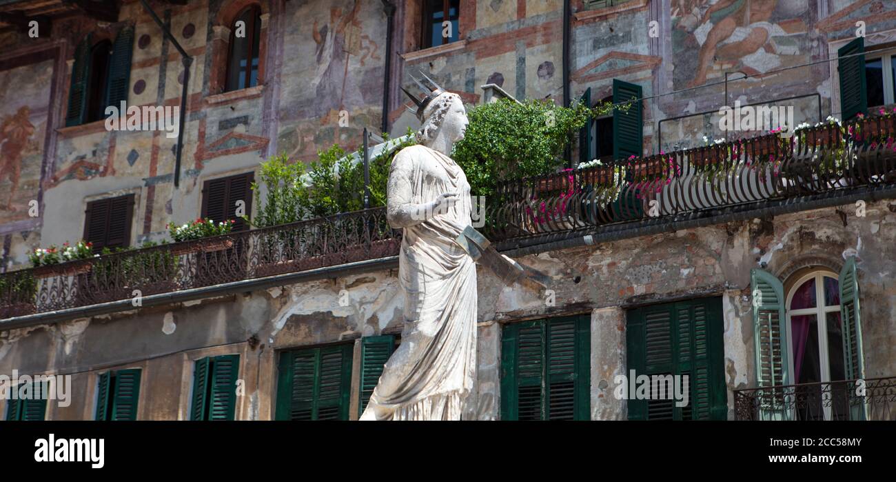 La fontaine de la Madonna de Vérone sur la Piazza Erbe, avec des façades peintes sur les bâtiments derrière, une caractéristique de la vieille ville. Banque D'Images
