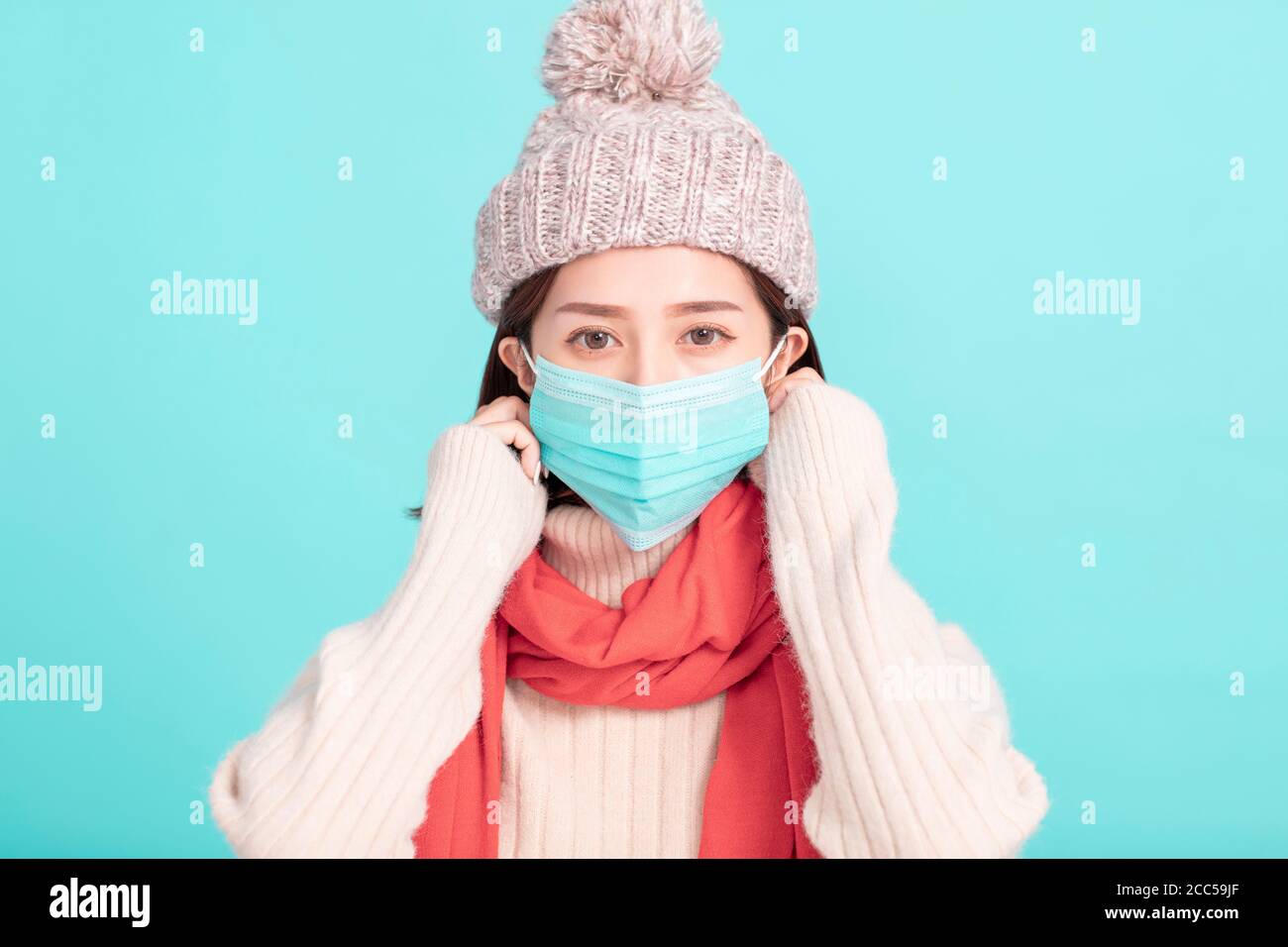 jeune femme en robe d'hiver et porter un masque médical Banque D'Images
