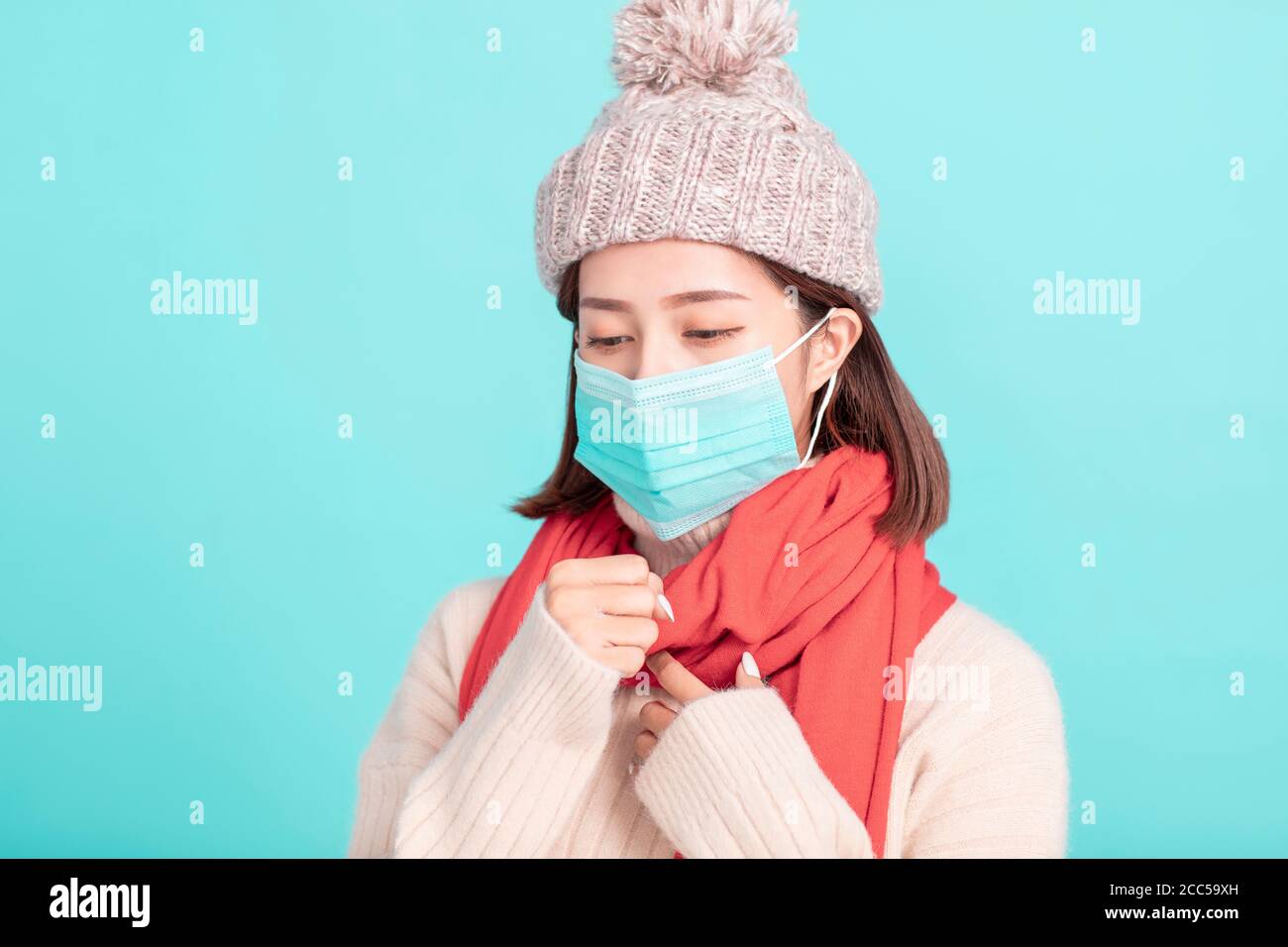 jeune femme en robe d'hiver et porter un masque médical Banque D'Images