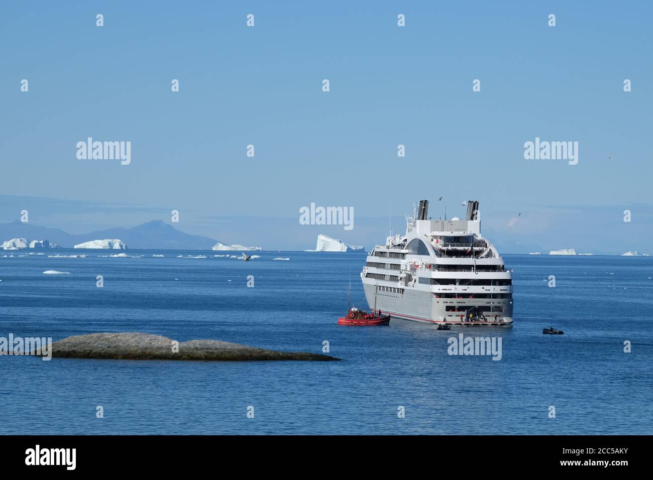 Passagers de paquebots de croisière à bord d'un bateau de pêche local pour tour d'icebergs et vues sur les bergs vêlage d'un des plus grands glaciers du monde Banque D'Images