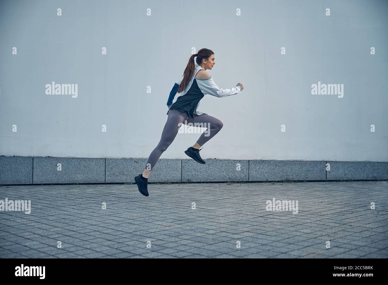 Femme sportive sérieuse flottant dans les airs Banque D'Images