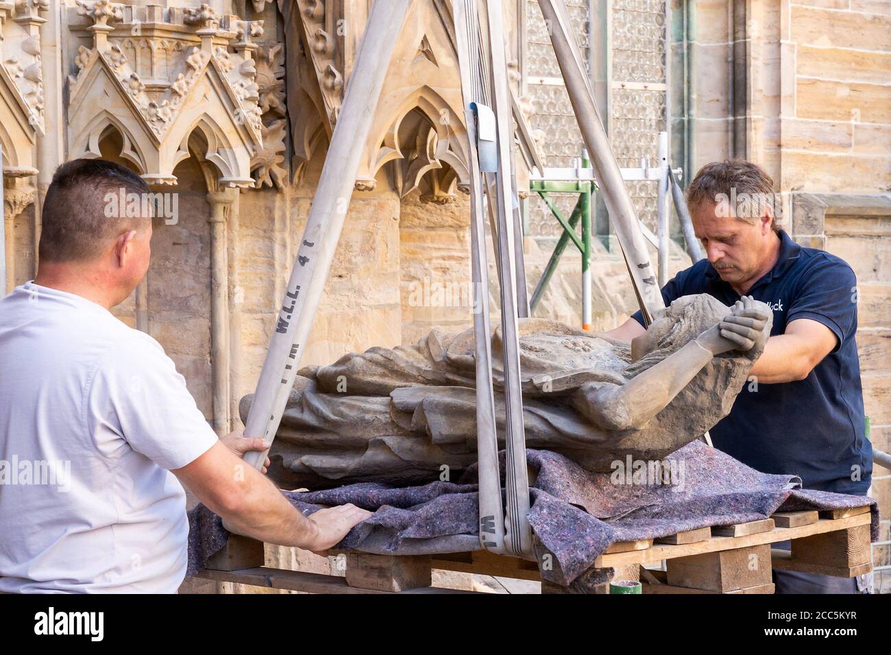 Erfurt, Allemagne. 19 août 2020. Jenö Csejoli (r) et Jozef Szabo, employé d'une entreprise de restauration, ont remis en place la première sculpture du Portail de la Vierge. Après sa restauration, le groupe de figures 'stupide Virgins' sera installé dans le portail vierge déjà rénové du triangle à la cathédrale d'Erfurt. Credit: Michael Reichel/dpa-Zentralbild/dpa/Alay Live News Banque D'Images