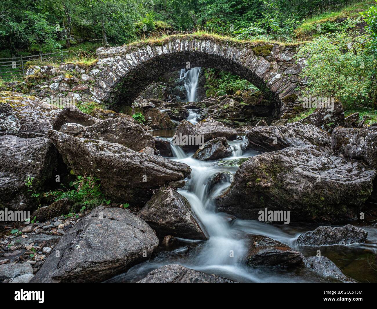 Un pont à cheval traversant un affluent sous une cascade sur la rive sud de la Lyon. C'est localement connu comme le pont romain, bien qu'actua Banque D'Images