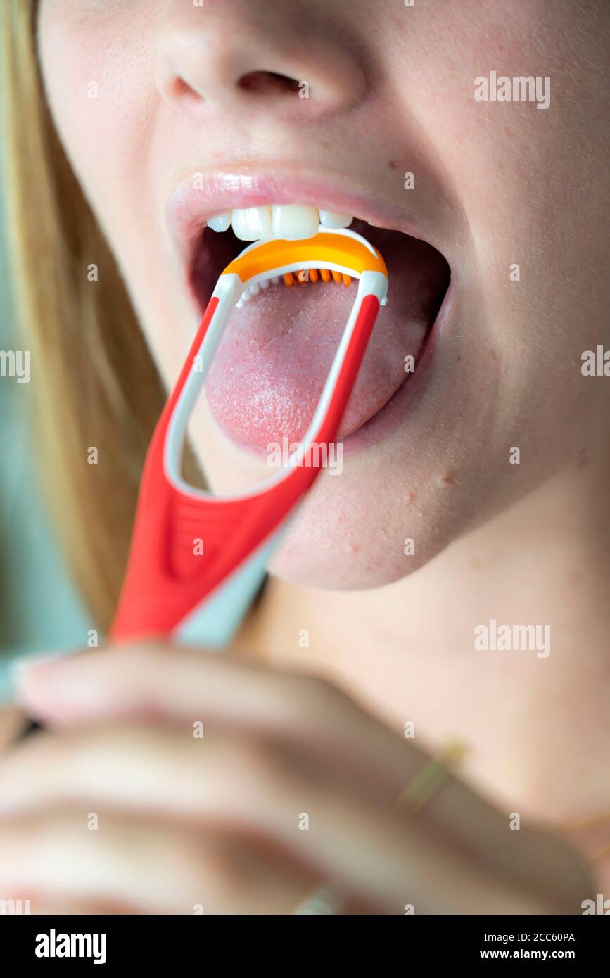 Mauvaise haleine, prévention en nettoyant la langue à l'aide d'une brosse pour langue Banque D'Images