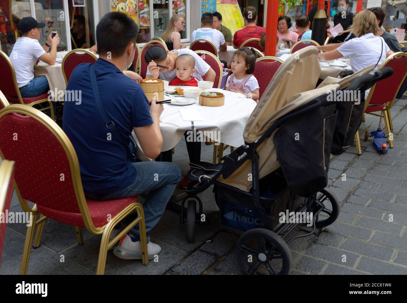 Londres, Angleterre, Royaume-Uni. Les personnes qui mangent à l'extérieur dans Gerrard Street, Chinatown Banque D'Images