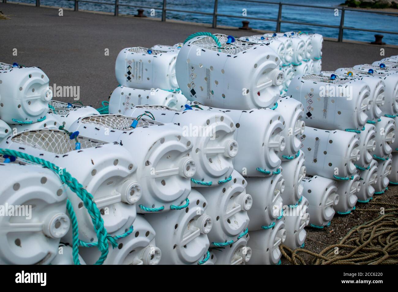 Cages de capture de crabe empilées et prêtes pour la prochaine utilisation, lignes de sarcelle fixées aux cages blanches, méthode créative d'utilisation des canisters en plastique, idée de recyclage du Royaume-Uni Banque D'Images