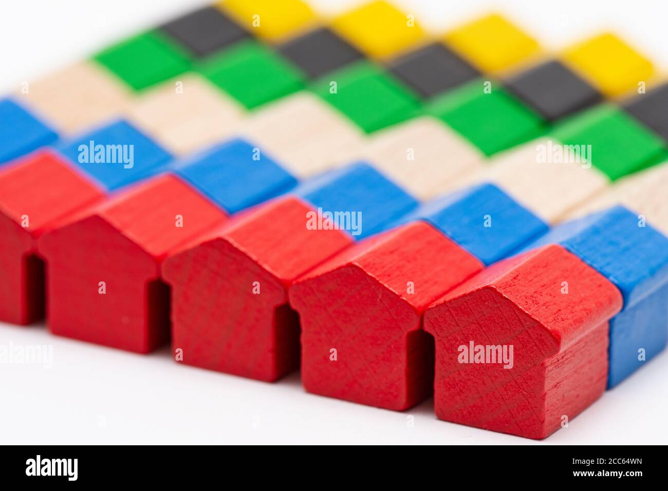 Rangées de petites maisons de jouets en bois peintes dans différentes couleurs Banque D'Images