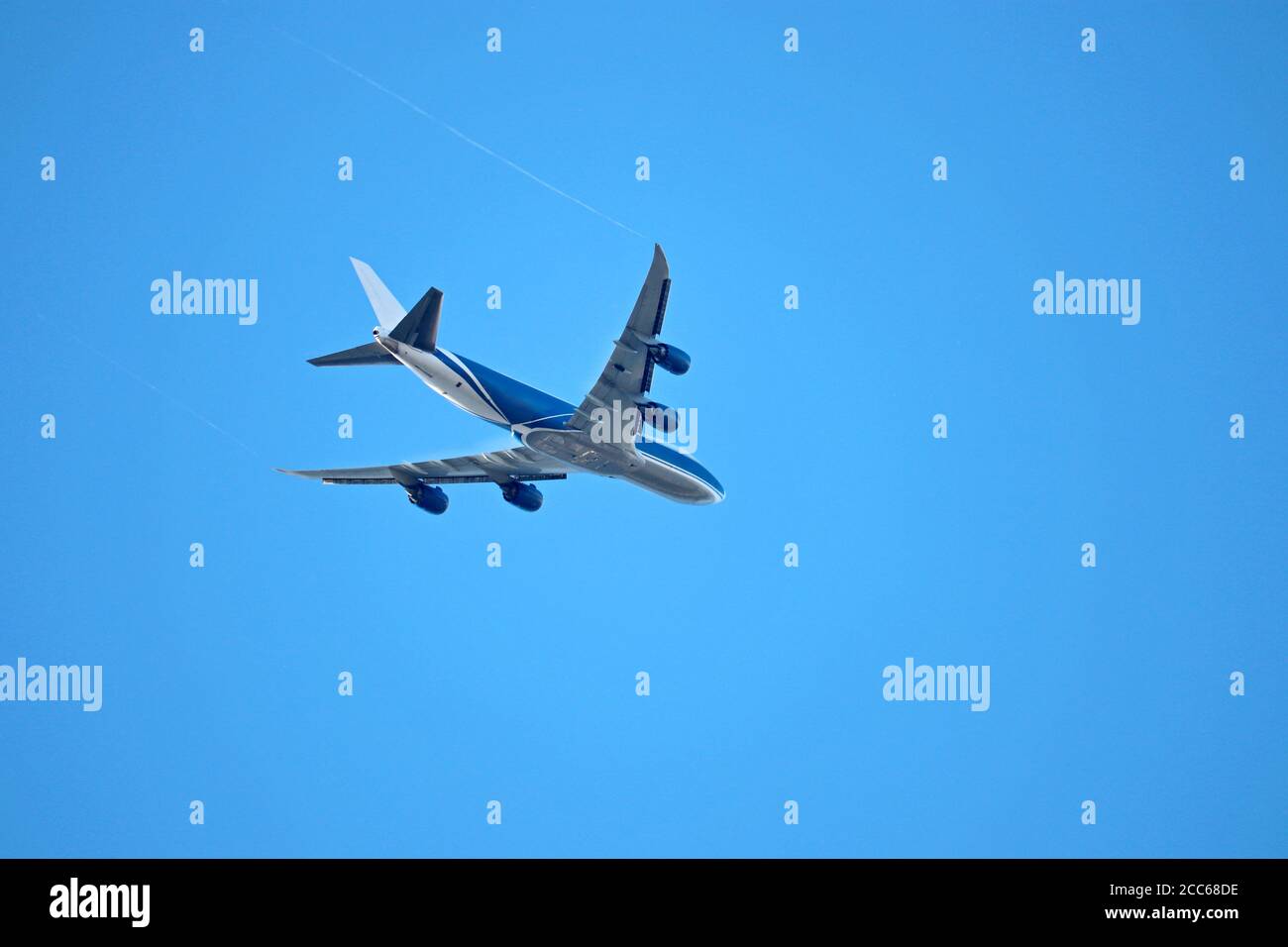 Avion volant dans le ciel bleu clair, vue de dessous. Décollage d'un avion commercial à quatre moteurs Banque D'Images