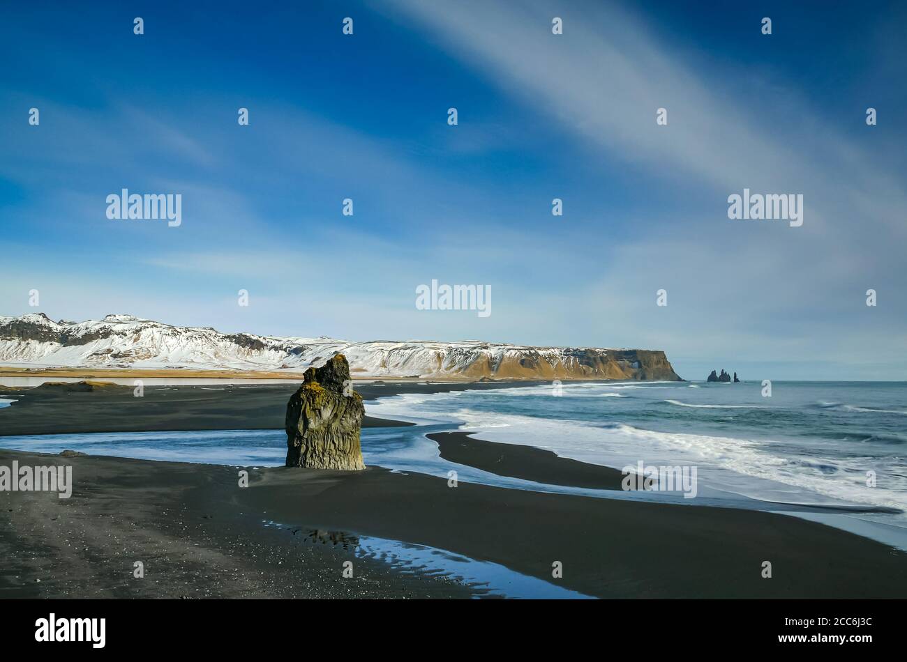 Dyrhólaey ou Cap Portland avec plage de lave noire et pile de mer en hiver le jour ensoleillé, Islande Banque D'Images