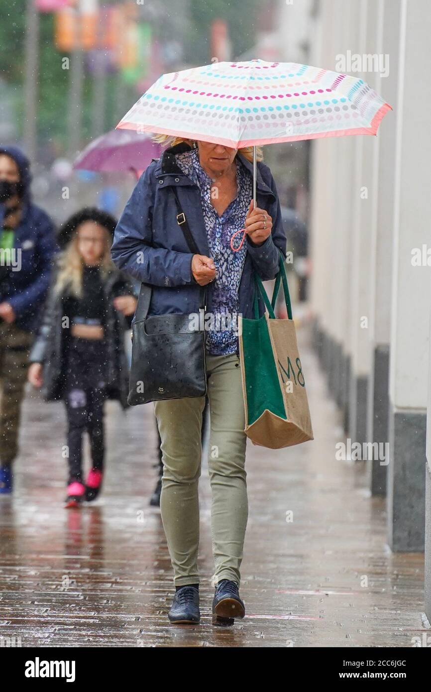 Sheffield, Royaume-Uni. 19 août 2020. Les acheteurs se cachent de la pluie sous un parapluie lors d'un important déversage à Sheffield cet après-midi. De grandes parties du Royaume-Uni seront touchées par la pluie aujourd'hui. Credit: Ioannis Alexopoulos/Alamy Live News Banque D'Images