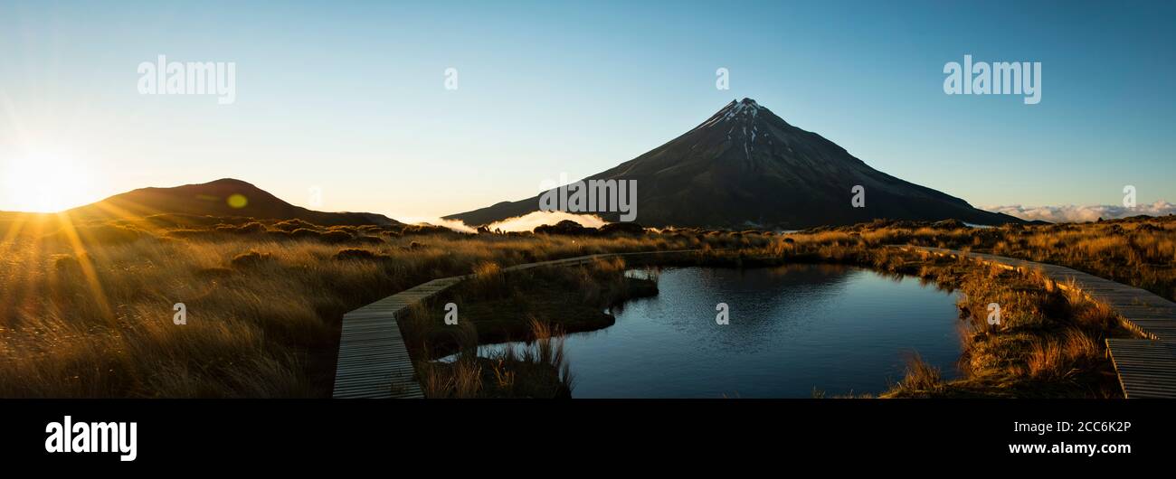 Image panoramique du Mont Taranaki reflétée dans le tarn de Pouakai à lever du soleil Banque D'Images