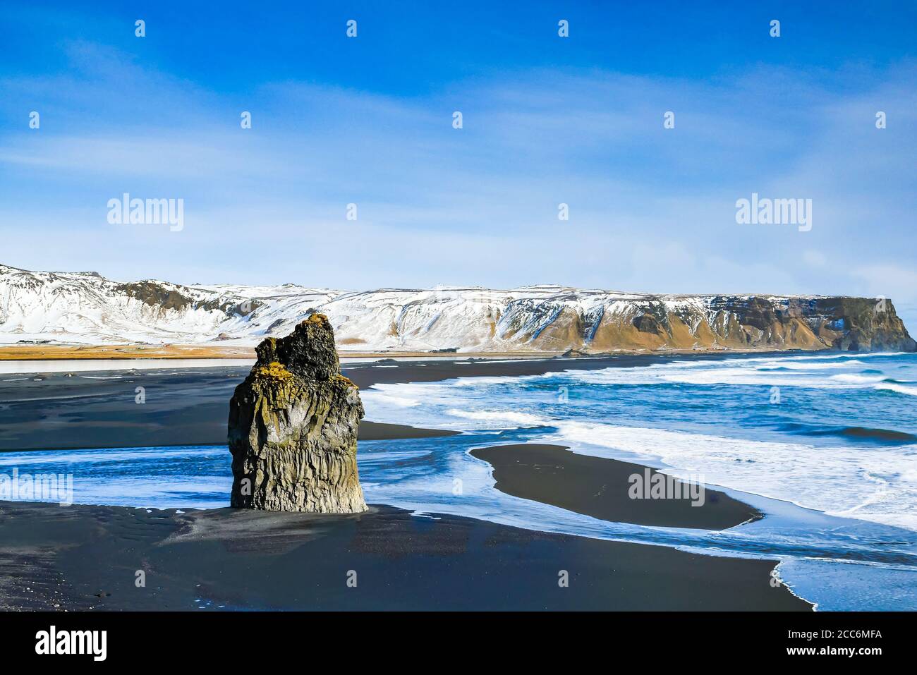 Dyrhólaey ou Cap Portland avec plage de lave noire et pile de mer en hiver le jour ensoleillé, Islande Banque D'Images