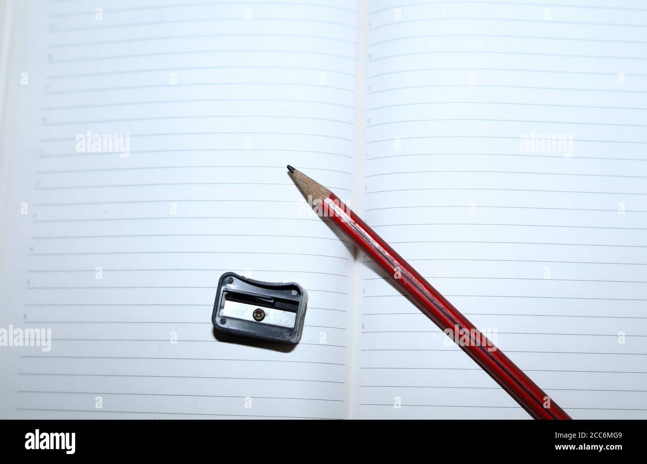 Crayons sur papier blanc pour ordinateur portable avec taille-crayons Banque D'Images