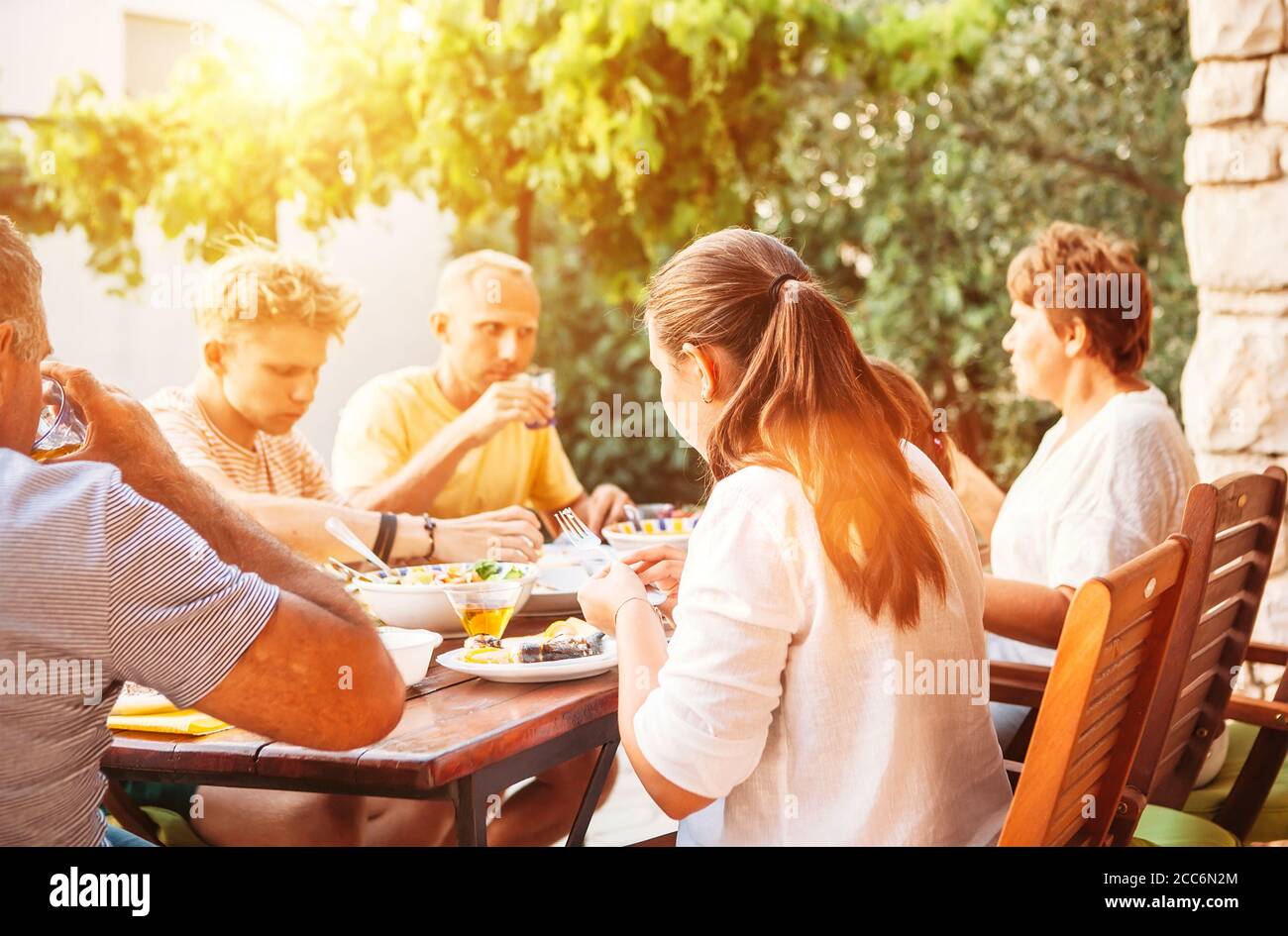 Une grande famille dîne sur la terrasse du jardin Banque D'Images