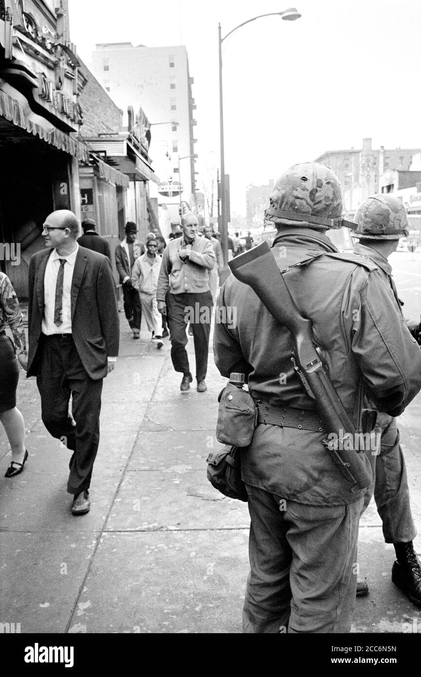 Des membres de la Garde nationale patrouillent dans les rues alors que des piétons se prominaient après les émeutes qui ont suivi l'assassinat du Dr Martin Luther King Jr, Washington, D.C., États-Unis, Warren K. Leffler, 8 avril 1968 Banque D'Images