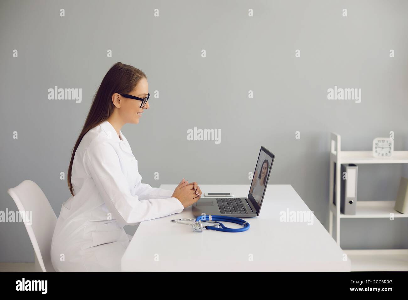 Jeune femme médecin consultant patient en ligne, en utilisant un ordinateur portable à son bureau. Le médecin traitant effectue un appel vidéo au client malade Banque D'Images