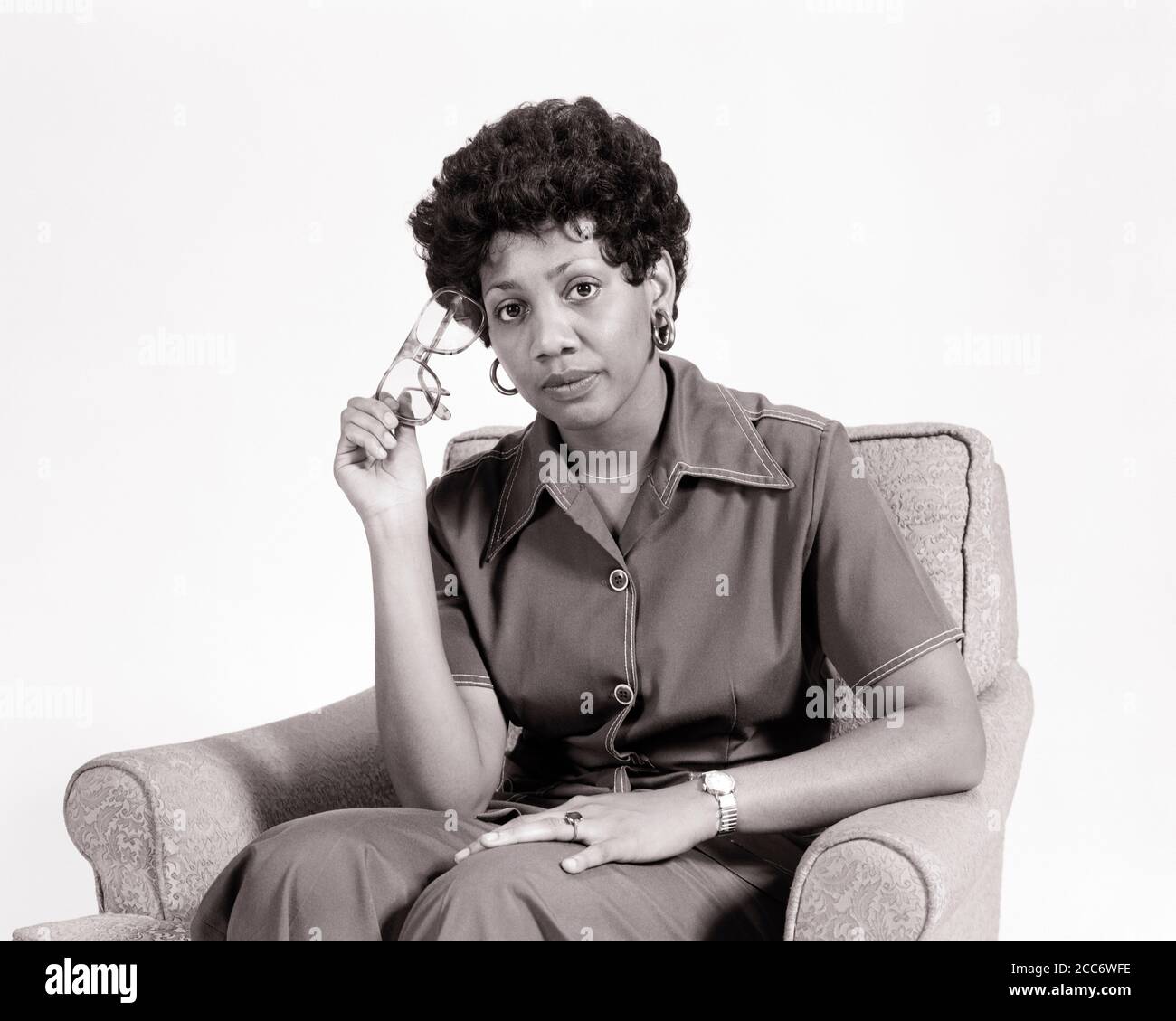 ANNÉES 1970 FEMME AFRO-AMÉRICAINE STYLE CURLY PORTANT DES BOUCLES D'OREILLES HOOP TENANT PAIRE LUNETTES REGARDANT LA CAMÉRA EXPRESSION SÉRIEUSE - G8465 HAR001 HARS FACIAL HOOP COMMUNICATION BALANCE SOUCI STYLE DE VIE CONSEILLER FEMMES EMPLOIS STUDIO SHOT MOODY MAISON VIE COPIE ESPACE FEMMES PERSONNES ATTENTIONNÉS BOUCLES D'OREILLES AFRO CONFIANCE SOIN LUNETTES EXPRESSIONS TROUBLÉE B&W CONCERNÉ TRISTESSE OEIL CONTACT COMPÉTENCE MÉTIER COMPÉTENCES TÊTE ET ÉPAULES STRATÉGIE AFRO-AMÉRICAINS AFRO-AMÉRICAIN COIFFURE SAVOIR LEADERSHIP NOIR ETHNICITÉ MAURIQUEMENT FIERTÉ HUMEUR OCCUPATIONS CONNEXION GLUM ENCORE VIE ÉLÉGANT SINCÈRE SOLENNEL Banque D'Images