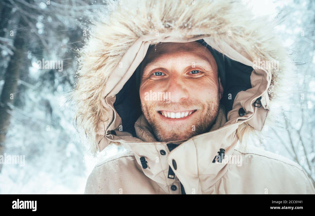 Homme habillé dans chaud capuche décontracté Parka veste Outerwear marchant  dans la forêt enneigée gai visage souriant portrait. Vêtements d'hiver et  d'heure d'extérieur concep Photo Stock - Alamy
