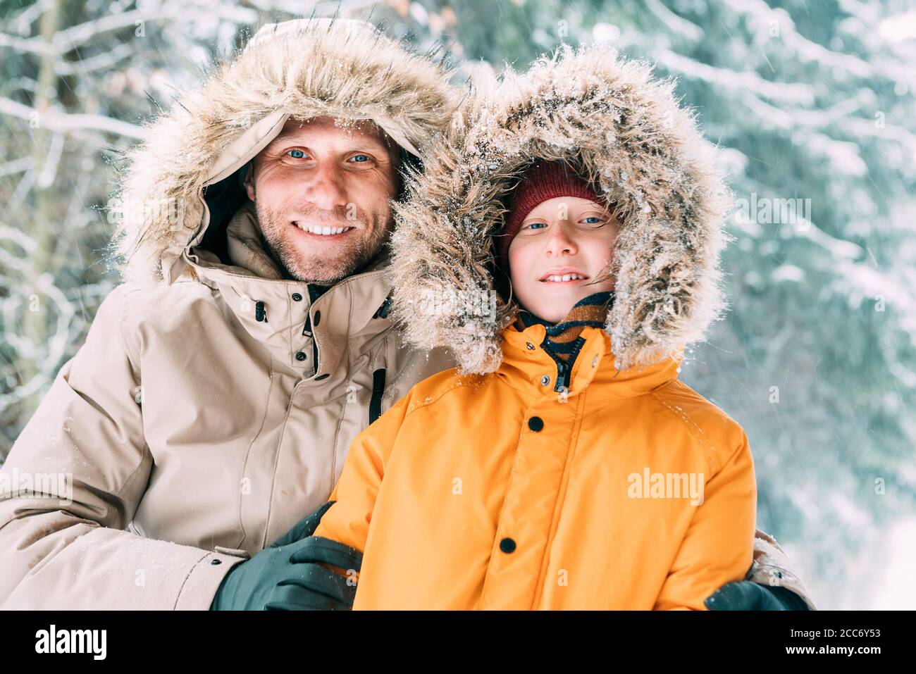 Père et fils vêtus de chaud capuche décontracté Parka Veste Outerwear  marche dans la forêt enneigée gaie souriant visages portrait. Père et fils  parents Photo Stock - Alamy